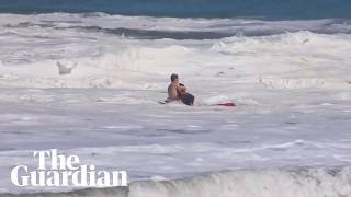 Teen lifeguard struggles to drag boy out of massive waves in California