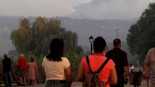 Spanish residents look on as a wildfire burns