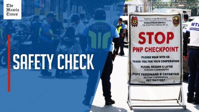 Police examine motorists' documents in Manila checkpoint